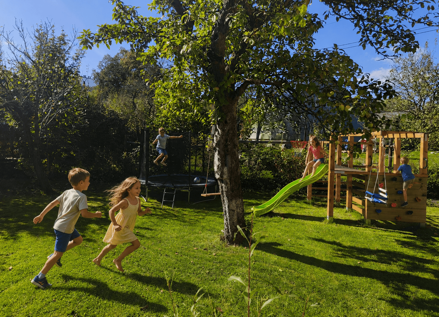 Děti na zahradě u hřiště a trampolíny